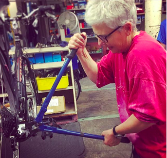 Gwen replacing rear wheel on bicycle at Cornell Outdoor Education bike maintenance clinic